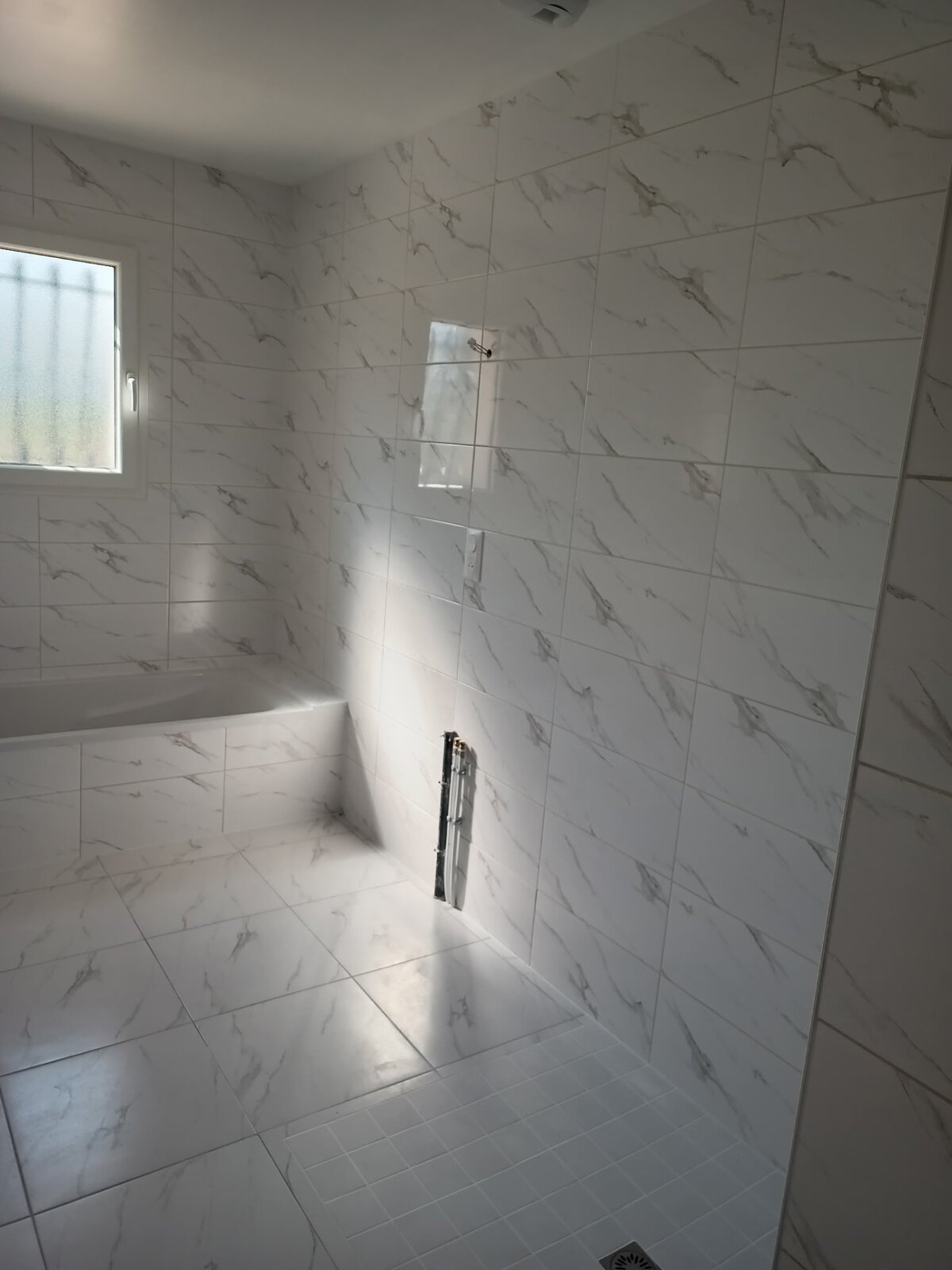 Pose de carrelage — salle de bains : Salle de bain marbre - Détail mural
